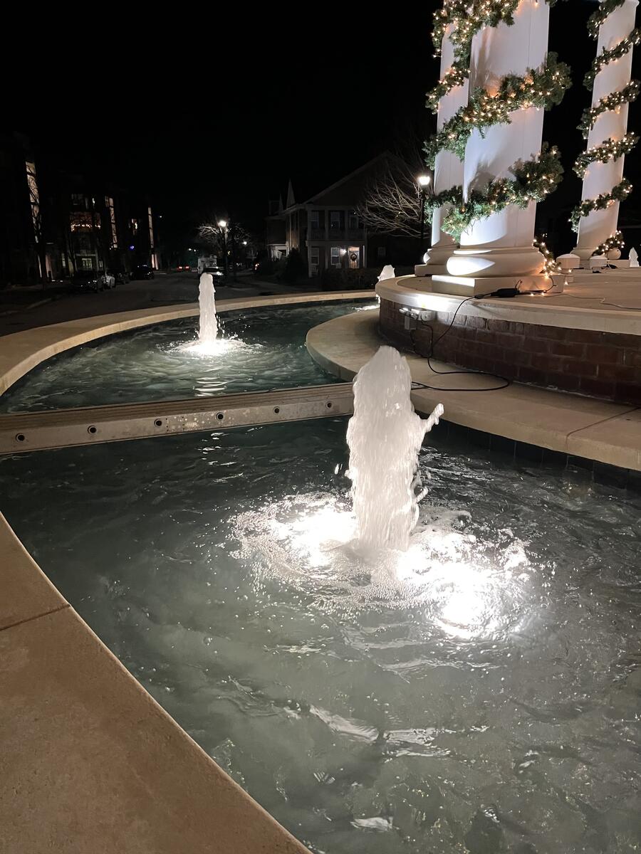 HOA fountain at night with holiday lights